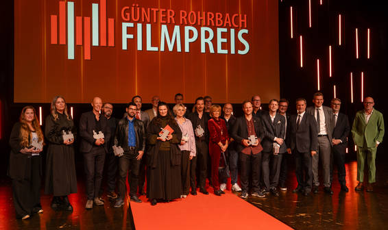 Menschengruppe vor rotem Theatervorhang