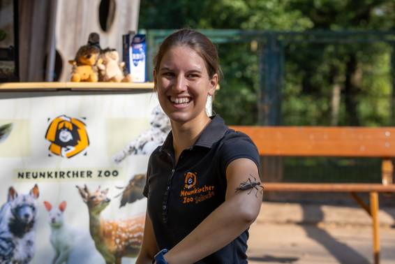 Zooguide mit einem großen Insekt auf dem Arm